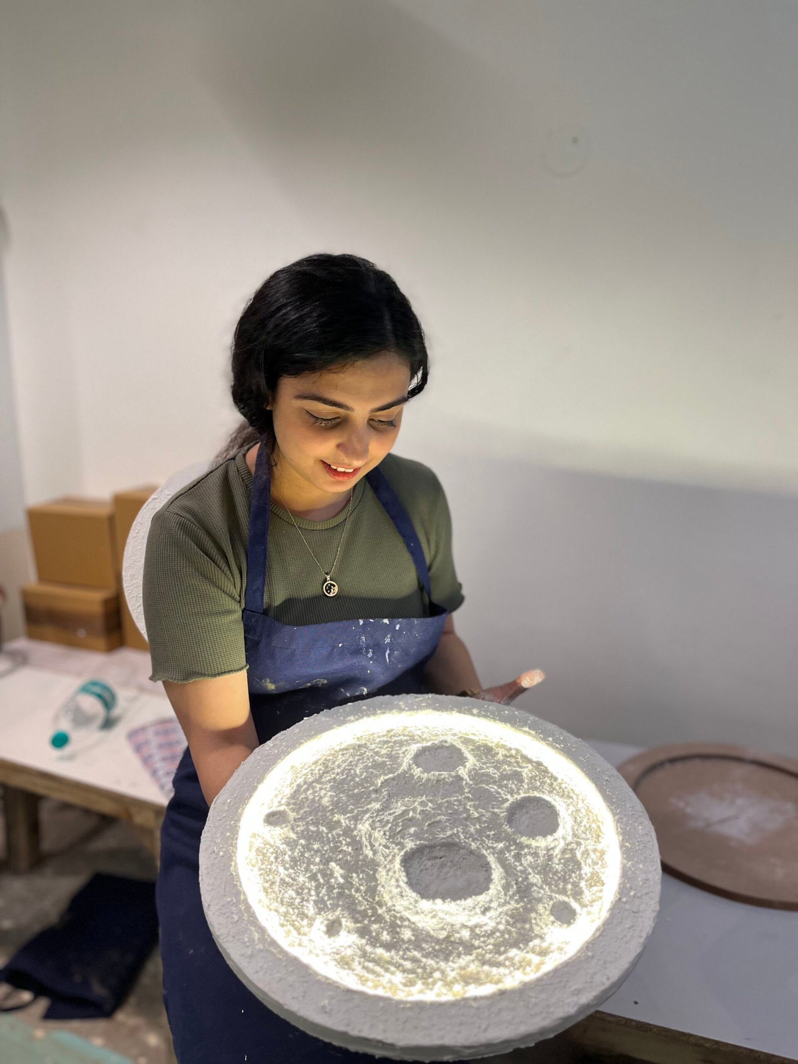 Participant creating a glowing moon art piece during a Chalkbooard workshop.