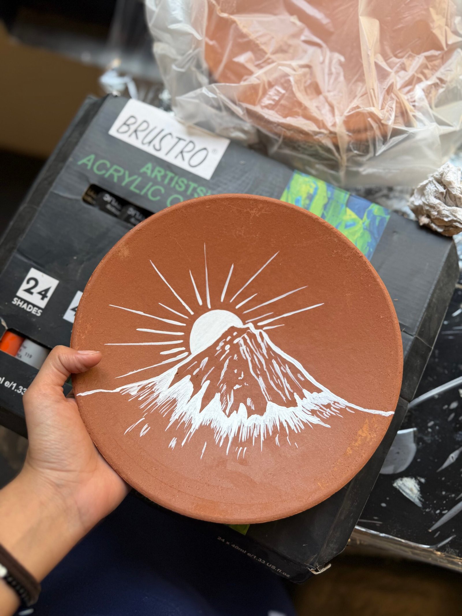 Participant creating a glowing moon art piece during a Chalkbooard workshop.